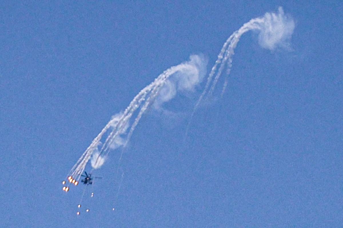 An Israeli Air Force attack helicopter releases flares during a flyover above the Gaza Strip on April 14, 2024 amid ongoing battles in the Palestinian territory between Israel and the militant group Hamas. AFP PHOTO