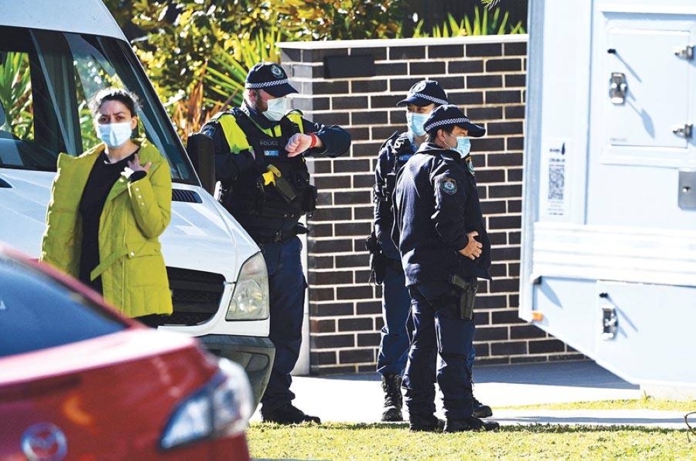 PERSISTENT SPIKE Police officers stand outside a residential building in the South Western Sydney suburb of Campbelltown on Aug. 4, 2021 after residents were placed in isolation due to reports of Covid-19 infections within the building. AFP PHOTO