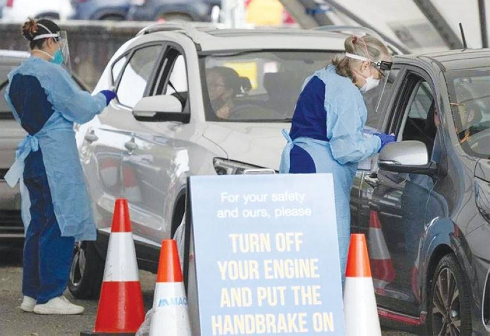 LETHAL RESURGENCE Staff collect samples at a drive-through Covid-19 testing clinic at Bondi Beach in Sydney, Australia on Saturday, Jan. 8, 2022. Australia’s most populous state has reinstated some restrictions and suspended elective surgeries as Covid-19 cases surged to another record. AP PHOTO