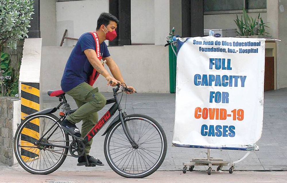 COVID WARD FULL A man rides past a sign informing the public that the Covid-19 ward of the San Juan de Dios Hospital is full. PHOTO BY MIKE ALQUINTO