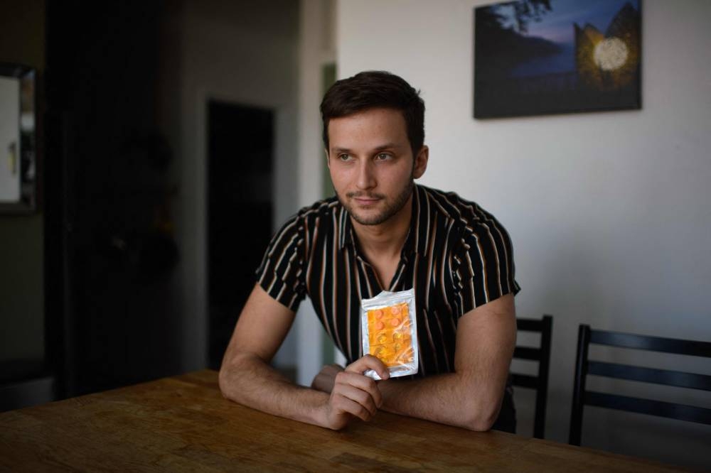 Philip Markle poses for a photo with a ketamine pill pack at his home in the Brooklyn borough of New York, on January 27, 2022. AFP PHOTO