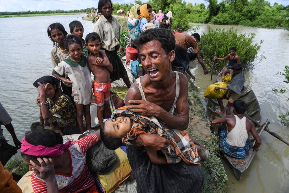 EDITORS NOTE: Graphic content / (FILES) In this file photo taken on October 9, 2017, a Rohingya refugee reacts while holding his dead son after crossing the Naf river from Myanmar into Bangladesh in Whaikhyang. - The United States has determined that the violence against the Rohingya minority committed by Myanmar's military amounted to genocide and crimes against humanity, an official told AFP on March 20, 2022. (Photo by Indranil MUKHERJEE / AFP)