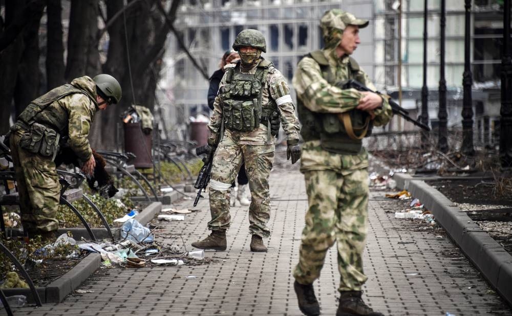 Russian soldiers walks along a street in Mariupol on April 12, 2022, as Russian troops intensify a campaign to take the strategic port city, part of an anticipated massive onslaught across eastern Ukraine, while Russia's President makes a defiant case for the war on Russia's neighbor. AFP PHOTO