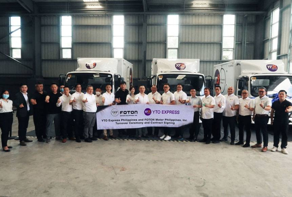 Foton Motor Philippines Inc. and YTO Express executives pose beside the Foton Tornado trucks during the turnover ceremony and contract signing. CONTRIBUTED PHOTO