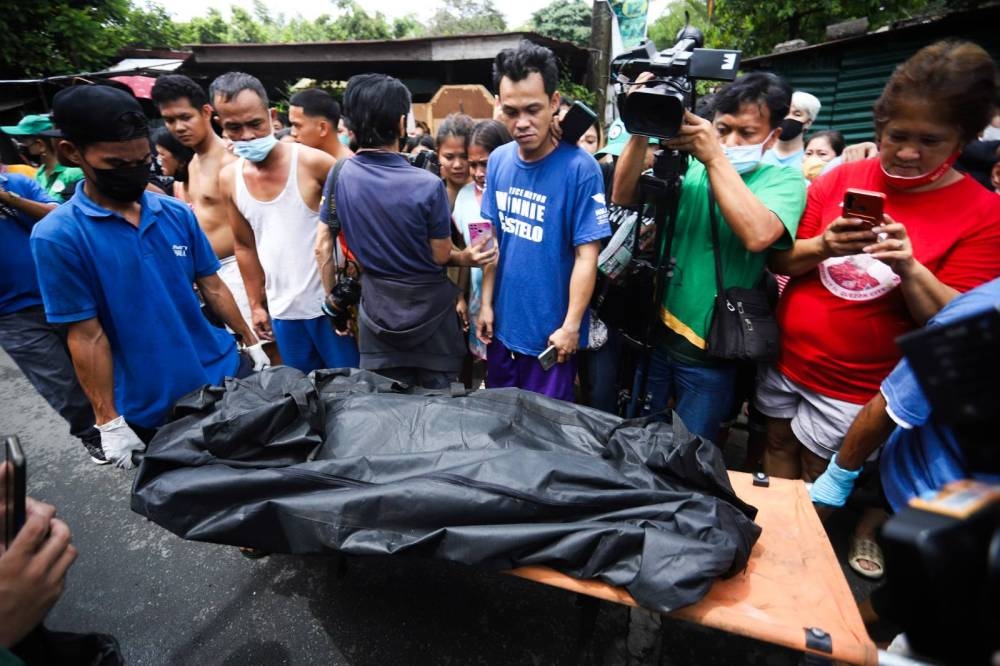Personnel of a funeral home retrieve one of the fire victims. PHOTO BY JOHN ORVEN VERDOTE