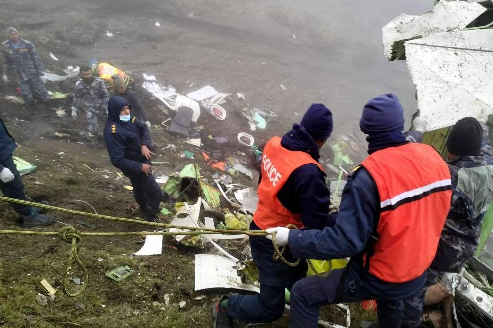 This handout photograph taken on May 30, 2022 and released by the Nepal Police shows members of a rescue team carrying out a operation at the crash site of a Twin Otter aircraft, operated by Nepali carrier Tara Air, on a mountainside in Mustang, a day after it crashed. AFP PHOTO/Nepal Police