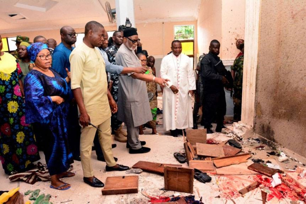 BLOODY SUNDAY Ondo Gov. Rotimi Akeredolu (third from left) points to a bloodstained floor after an attack at St. Francis Catholic Church in Ondo’s Owo town in southwestern Nigeria on Sunday, June 5, 2022. AFP PHOTO