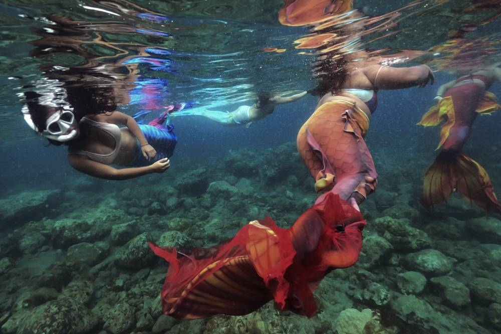 Filipina Jennica Secuya (left) swims with other students during a mermaiding class in Mabini, Batangas province, Philippines on Sunday, May 22, 2022. AP PHOTO