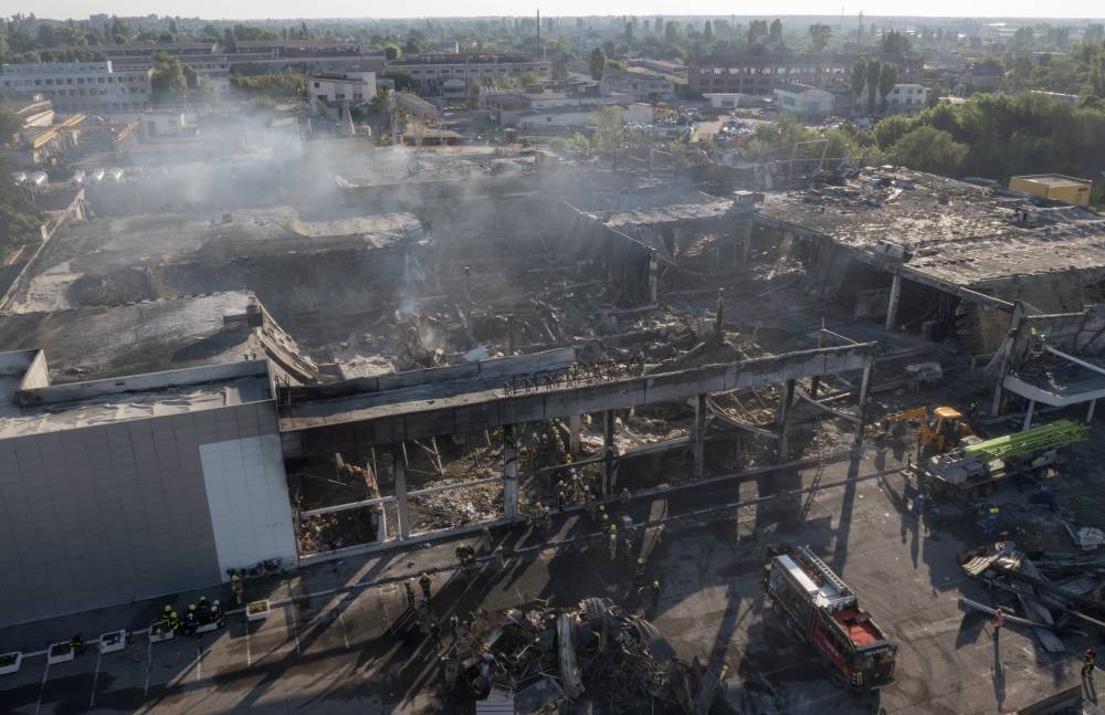 Ukrainian State Emergency Service firefighters work to take away debris at a shopping center burned after a rocket attack in Kremenchuk, Ukraine, Tuesday, June 28, 2022. AFP PHOTO