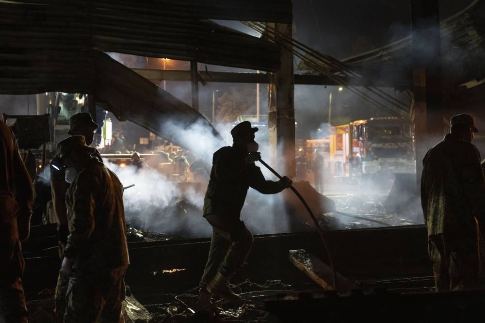 Volunteers and State Emergency Service firefighters work to extinguish a fire at a shopping center burned after a rocket attack in Kremenchuk, Ukraine, early Tuesday, June 28, 2022. AP PHOTO