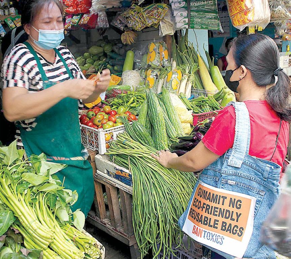 IN THE BAG A woman totes a reusable bag as she buys vegetables at a public market on Sunday, July 3, 2022. Ban Toxics group encouraged shoppers and vendors to abandon single use plastic bags and choose eco-friendly alternatives. PHOTO BY MIKE DE JUAN