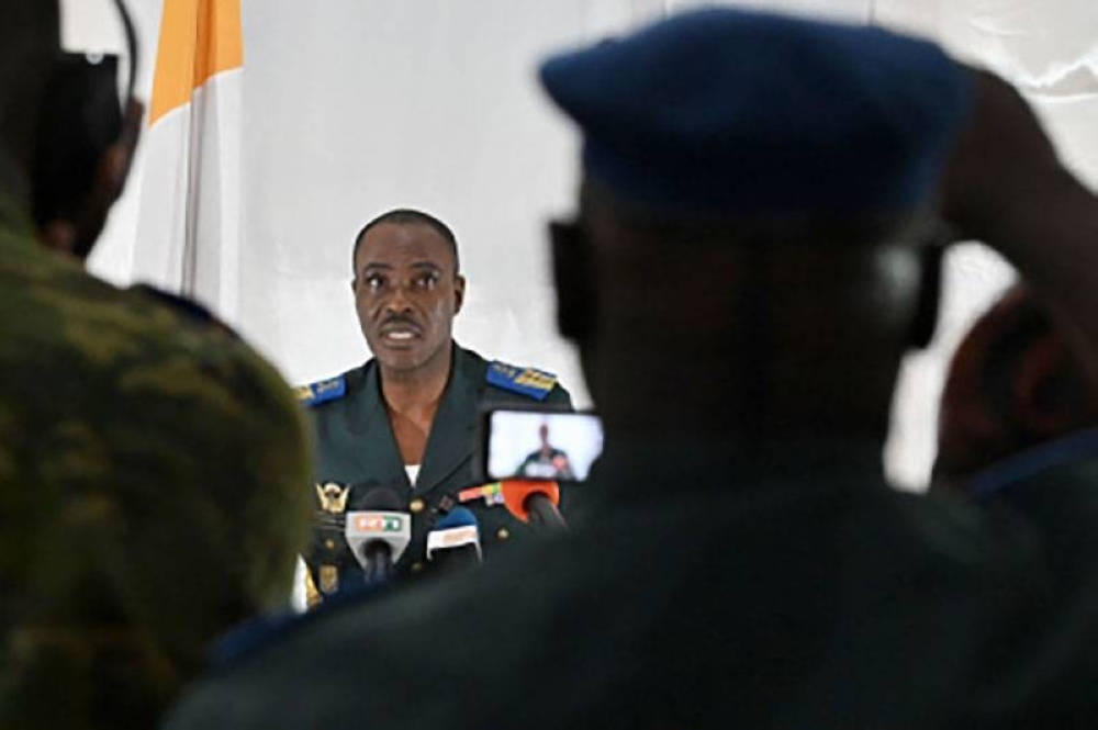 Ivorian army officer Colonel Armand Guzoa Mahi (center) addresses a press statement at the army headquarter in Abidjan on July, 13, 2022. On July 12, 2022, Ivory Coast called on Mali to release 49 of its soldiers 'unjustly' detained at Bamako airport and accused by officials there of being mercenaries. AFP PHOTO