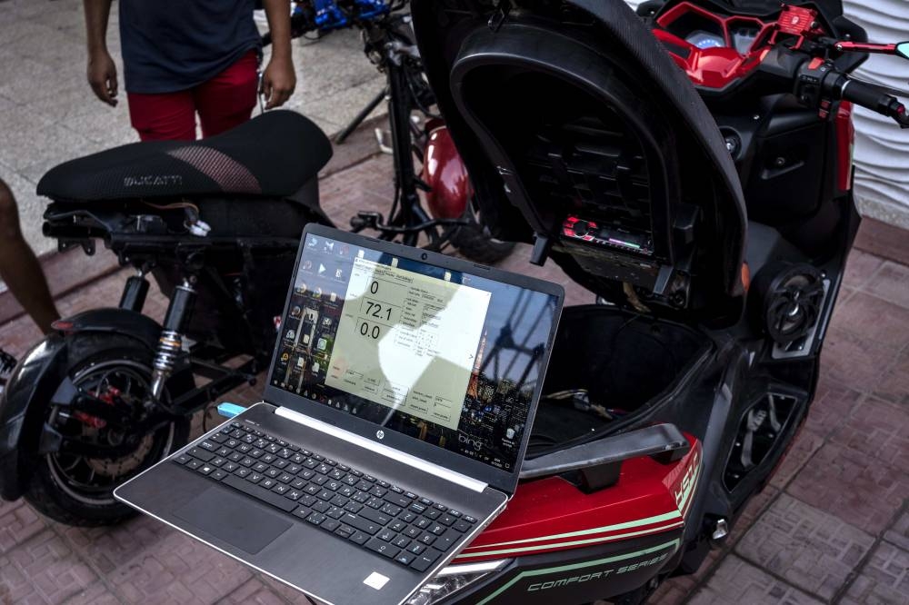 A laptop reads the voltage of an electric scooter after it was used at a gathering in the capital for stunts and races  in Cojimar, Cuba, Friday, July 15, 2022. AP PHOTO