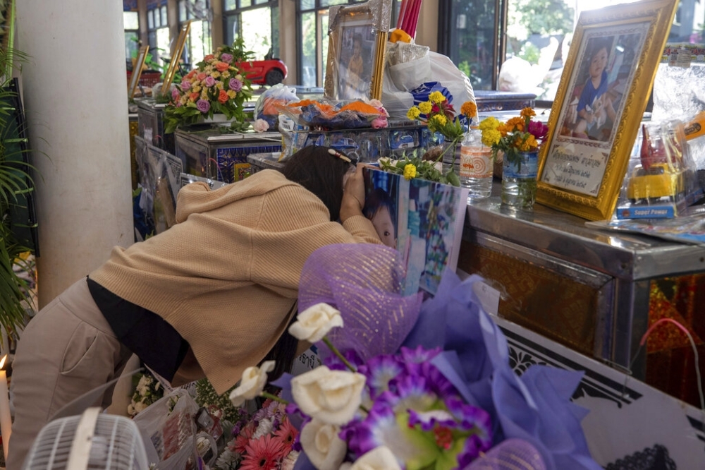 MOURNING IN THE MORNING A mother speaks to her child through the coffin, a victim of Thursday’s day care massacre inside Wat Rat Samakee temple in the town of Uthai Sawan, northeastern Thailand on Saturday, Oct. 8, 2022. AP PHOTO