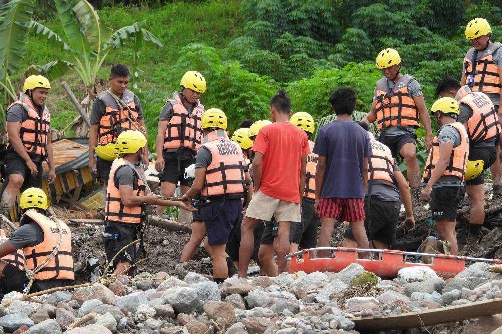 GRIM TASK Rescuers dig among mud and stones near a river as they try to retrieve the bodies of victims of a landslide in Kusiong village in Datu Odin Sinsuat in the southern Philippines’ Maguindanao province on Saturday, Oct. 29, 2022. Severe Tropical Storm ‘Paeng’ whipped the Philippines after unleashing flash floods and landslides that officials said left at least 45 people dead. AFP PHOTO