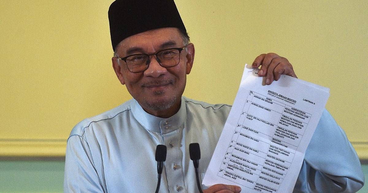Malaysian Prime Minister Anwar Ibrahim holds a document during a news conference to announce new Cabinet members at his office in Putrajaya on Dec. 2, 2022. AFP PHOTO