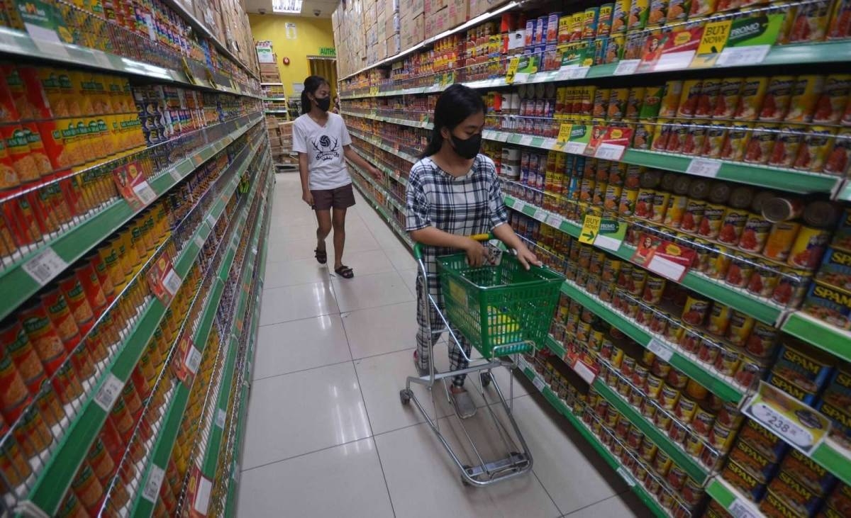 A shopper looks at canned goods inside a supermarket in Manila on Tuesday, Dec. 6, 2022. According to the Philippine Statistics Authority inflation jumped from 7.7% to 8% in November 2022, the highest recorded since the 9.1% in November 2008. The PSA attributed the spike to the high prices of food and non-alcoholic beverages, which rose to 10% in November from 9.4% in October. PHOTO BY MIKE ALQUINTO