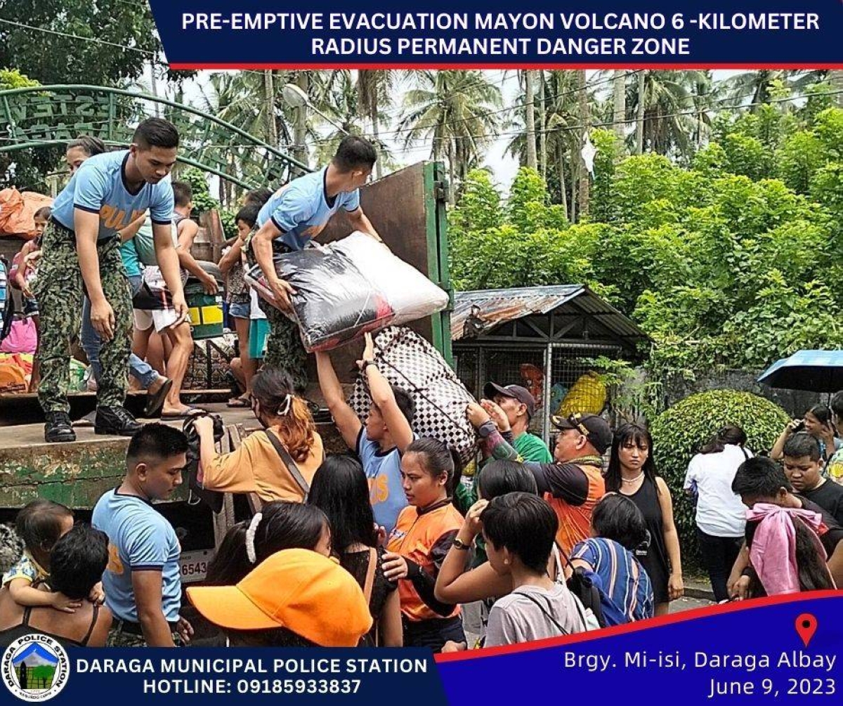 MOVING OUT OF HARM'S WAY Members of the Philippine National Police in Daraga, Albay help residents in the area evacuate on Friday, June 9, 2023, after the Philippine Institute of Volcanology and Seismology (Phivolcs) said earlier in the day that a 'hazardous eruption' is expected from Mayon Volcano at anytime. Daraga is within the six-kilometer danger zone set by Phivolcs. PHOTO FROM DARAGA MUNICIPAL STATION/FACEBOOK