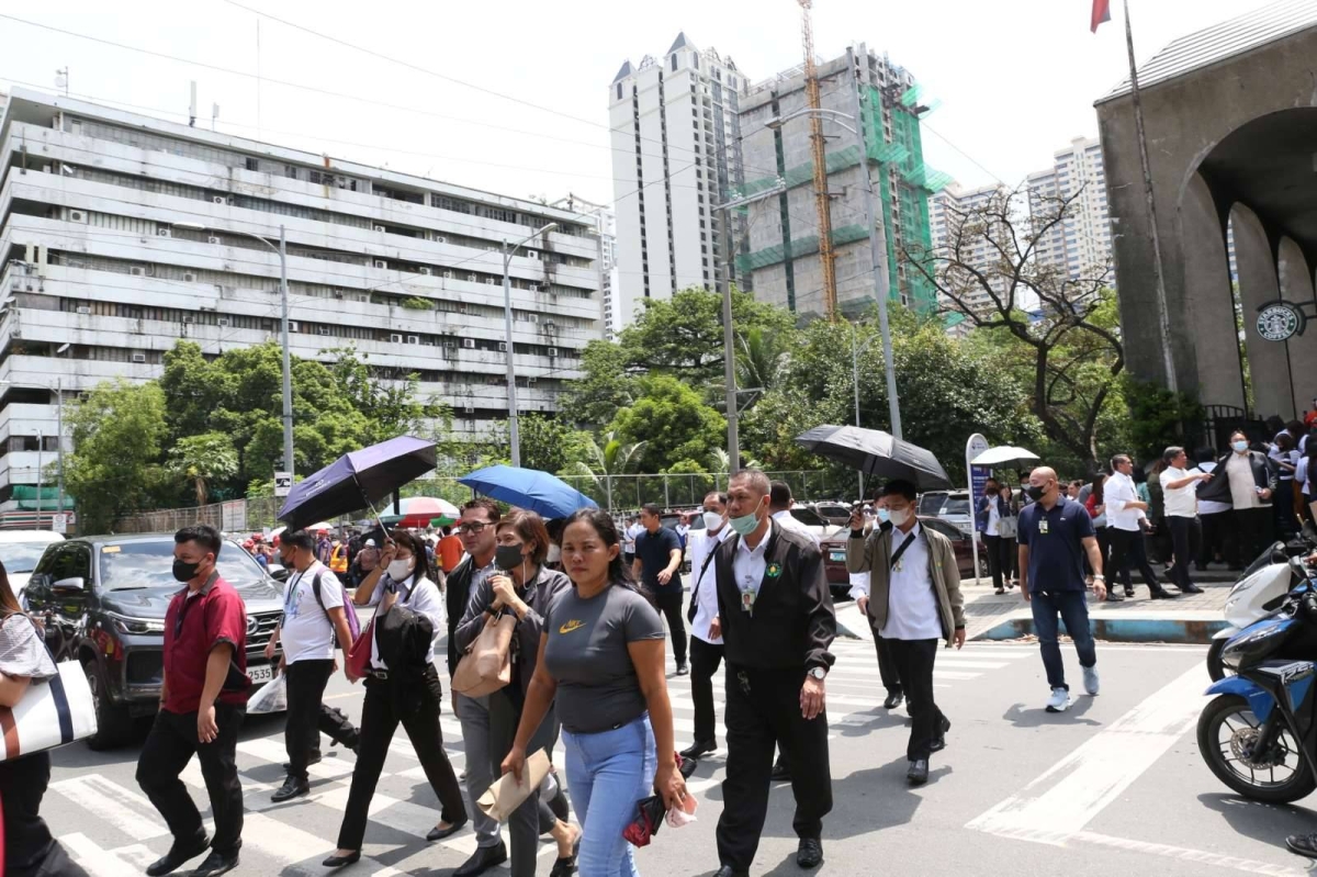 Quake Walk People walk out of office buildings in Manila following earthquake ...