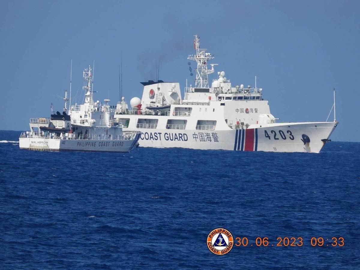 In this handout photo taken on June 30, 2023 and received from the Philippine Coast Guard (PCG) on July 5, a Chinese Coast Guard ship (R) allegedly blocks Philippine Coast Guard patrol ship Malabrigo, as it escorts a Philippine Navy re-supply mission near Second Thomas Shoal in the disputed South China sea. Handout / Philippine Coast Guard (PCG) / AFP