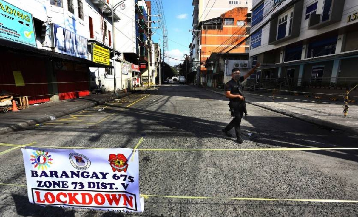 A policeman patrols a street in Barangay 675 Zone 73 in Paco, Manila on March 17, 2021. Manila Mayor Francisco ‘Isko Moreno’ Domagoso ordered the lockdown of Barangay 675 and five other villages on March 15 due to the rising number of Covid-19 cases.