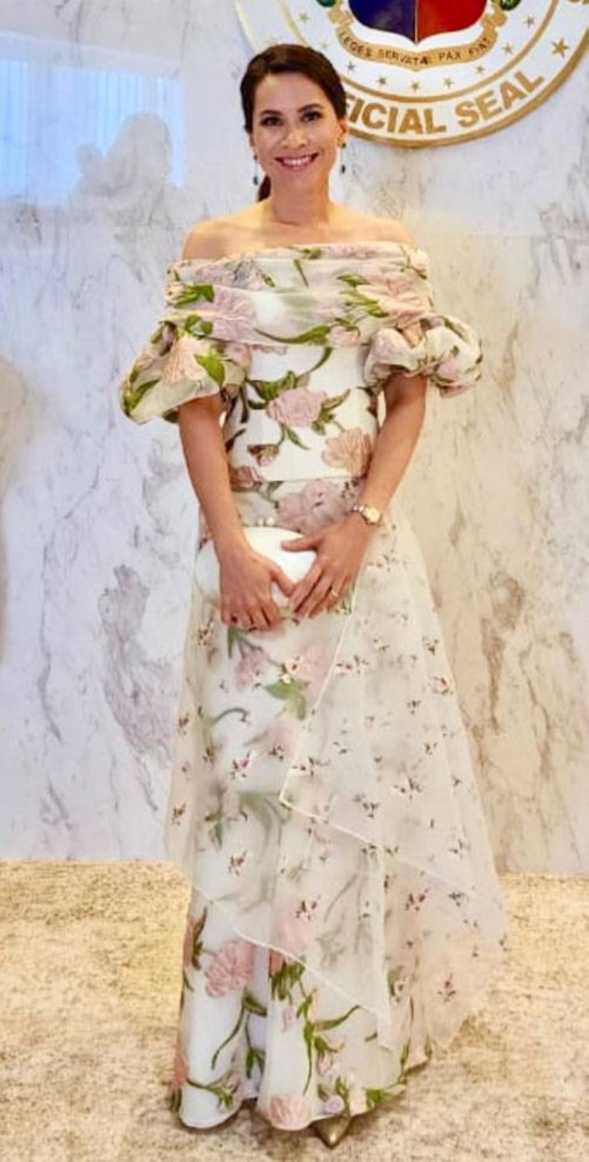 AUDREY TAN-ZUBIRI Consistently in the SONA best-dressed club, Audrey Tan-Zubiri, wife of Senate President Miguel Zubiri, joins this year’s floral Filipiniana trend in an off-the-shoulder gown by Rajo Laurel. The celebrated Filipino couturier names his charming creation “Panuelo and Tapis,” elaborating on Instagram that it is “a mix of patterns and embroidery for a contemporary take on the Filipiniana.” Tan-Zubiri completes the look with minimal accessories – slim and elegant dangling earrings, a lady’s dress watch, and an oval clutch bag from Beatriz. INSTAGRAM PHOTO/AUDREYTANZUBIRI