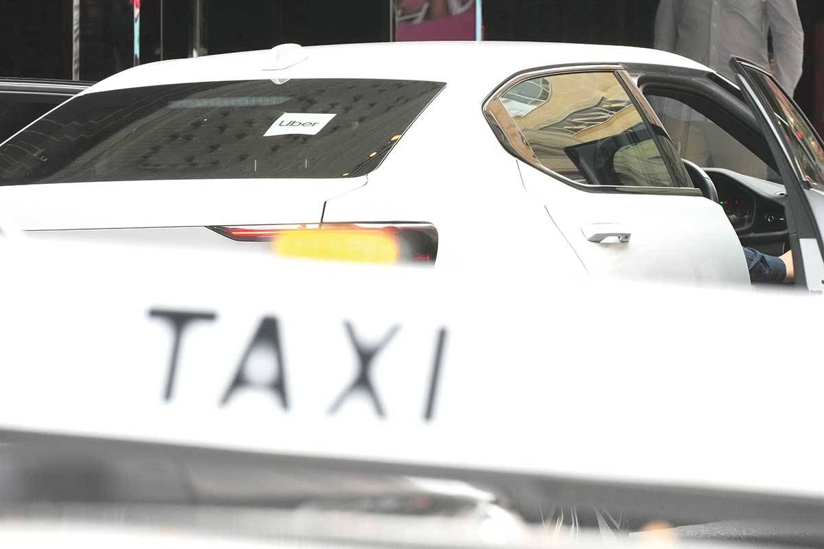 SETTLEMENT An Uber vehicle stops across the road from a taxi rank in Sydney, Australia, on Monday, March 18, 2024. Uber will pay AU$272 million ($178 million) to Australian taxi and hire car drivers who lost out when it entered the Australian market. AP PHOTO