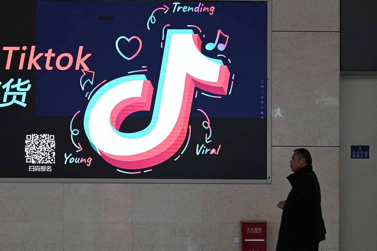 A man walks past an advertisement featuring the TikTok logo at a train station in Zhengzhou, in China’s central Henan province on January 21, 2024. GREG BAKER / AFP