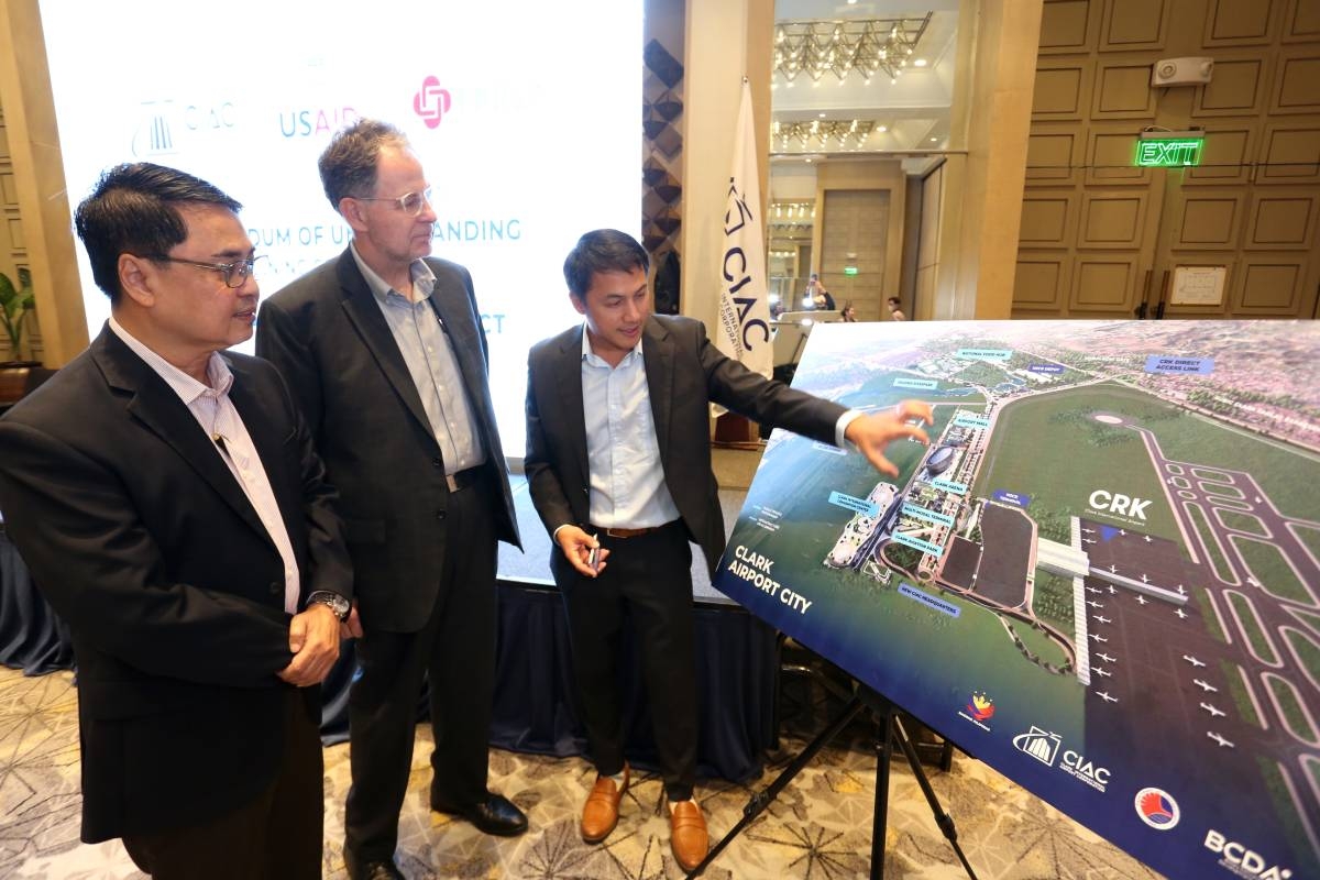  Clark International Airport Corp. President and CEO Arrey Perez (right) expounds to University of the Philippines Public Administration Research and Extension Services Foundation chief of party Dr. Enrico Basilio (left) and USAid deputy director Dr. Eric Florimon-Reed (center) the plan for the establishment of the 64-hectare Clark National Mega Food Hub, which is one of CIAC’s 7 Flagship Projects, at the Clark Civil Aviation Complex during the signing of the memorandum of understanding at the Quest Plus Conference Center-Clark in the Clark Freeport Zone in Pampanga. CONTRIBUTED PHOTO