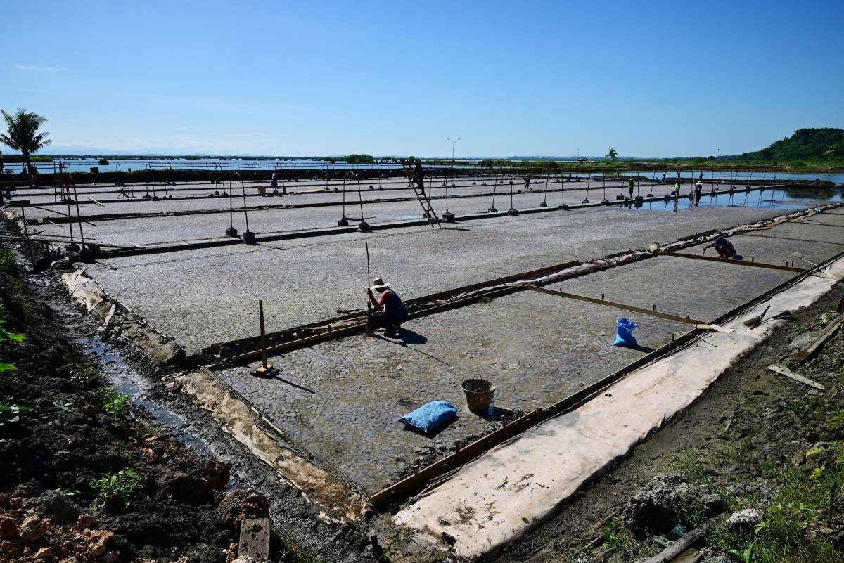 SALT HARVEST A worker installs ceramic tiles on a section of one of the salt beds of the Pangasinan Salt Center in Barangay Zaragoza, Bolinao town. The Pangasinan provincial government will be having its first harvest on Dec. 21, 2023. CONTRIBUTED PHOTO