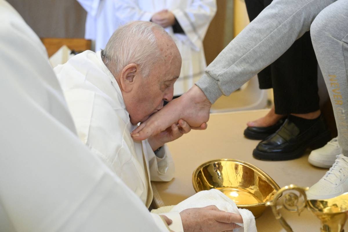 NO GENDER This photo taken on Holy Thursday, March 28, 2024, by The Vatican Media shows Pope Francis kissing the foot of an inmate at the 'Washing of the Feet' during a private visit at the Rebibbia prison for women in Rome as part of the Holy Week rituals. VATICAN MEDIA/AFP