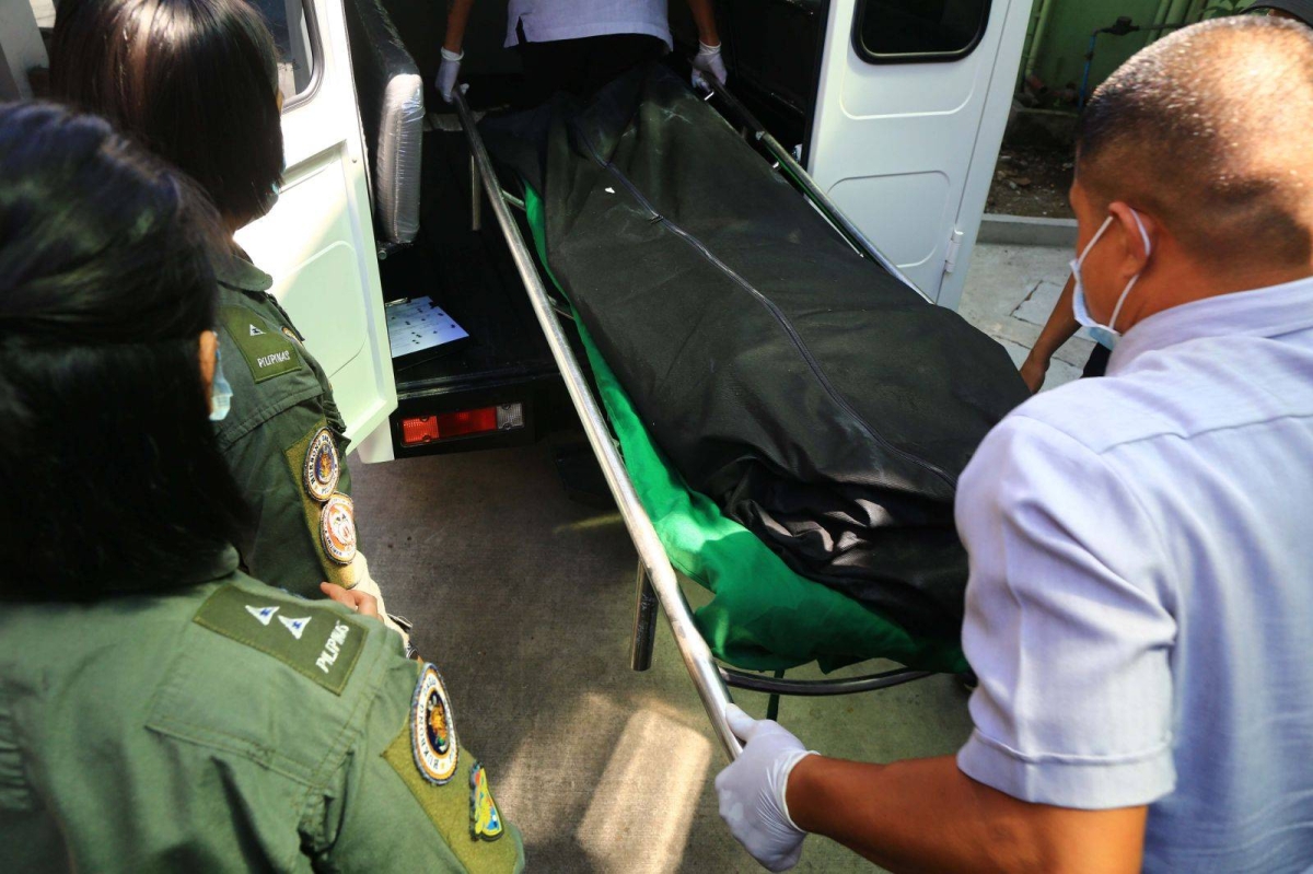 The bodies of two Philippine Navy pilots who died in a helicopter crash near the Cavite City Public Market during a training on Thursday, April 11, 2024 are carried onto a van as fellow soldiers watch. An investigation is underway to determine the cause of the accident. PHOTOS BY MIKE ALQUINTO