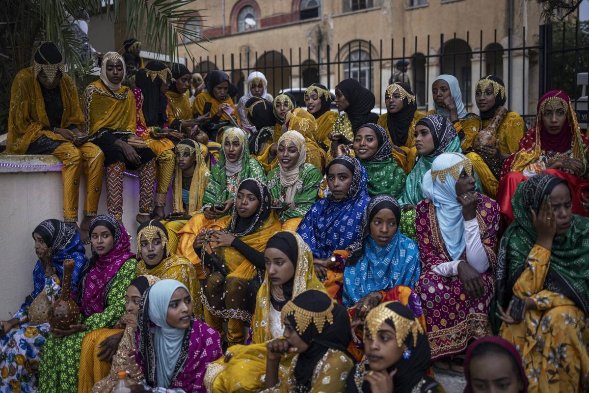 Young women dressed in traditional attires rest after a parade during the celebration for the Shuwalid festival in Harar on April 16, 2024. AFP PHOTO