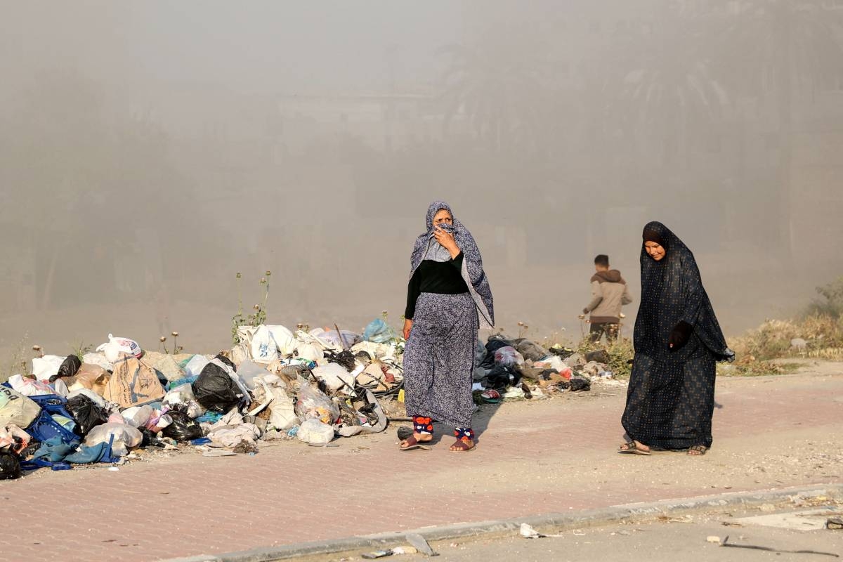 Women walk as smoke engulfs the area after Israeli bombardment at Al-Daraj neighbourhood in Gaza City on April 16, 2024, amid ongoing battles between Israel and the Palestinian Hamas movement. AFP PHOTO