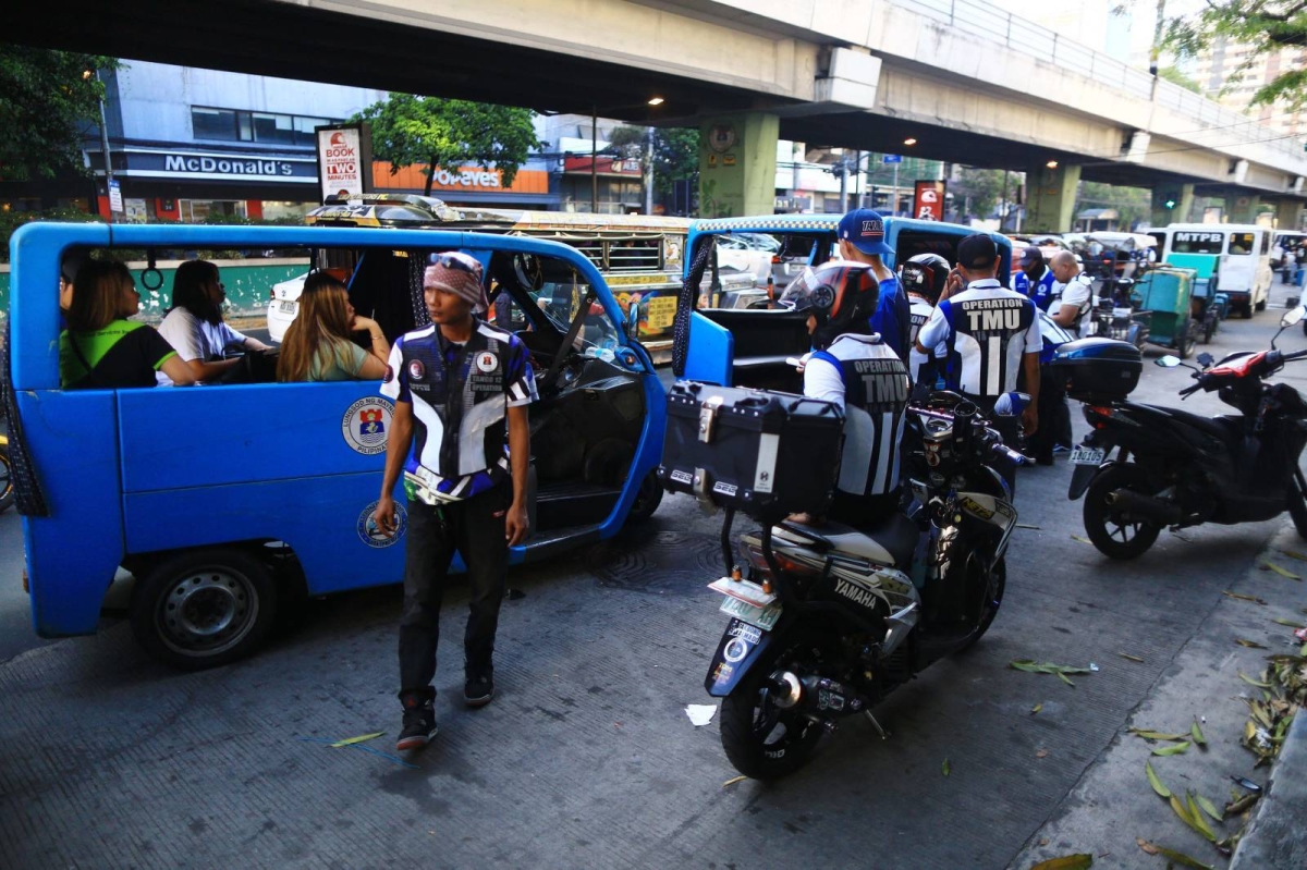 Personnel of the Manila Traffic and Parking Bureau issue violation tickets to electric bike and e-trike drivers on the first day of the ban on electric bikes and trikes. The Metropolitan Manila Development Authority on Monday said apprehended drivers were given a warning but violation tickets will be issued beginning April 17, 2024. PHOTO BY MIKE ALQUINTO