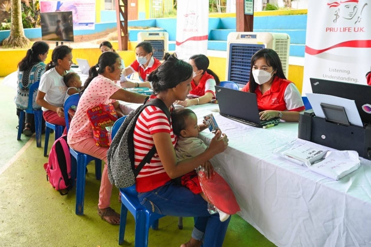 Families happily receive the FREE PRUMedCare-Select Infectious Disease coverage voucher. CONTRIBUTED PHOTO