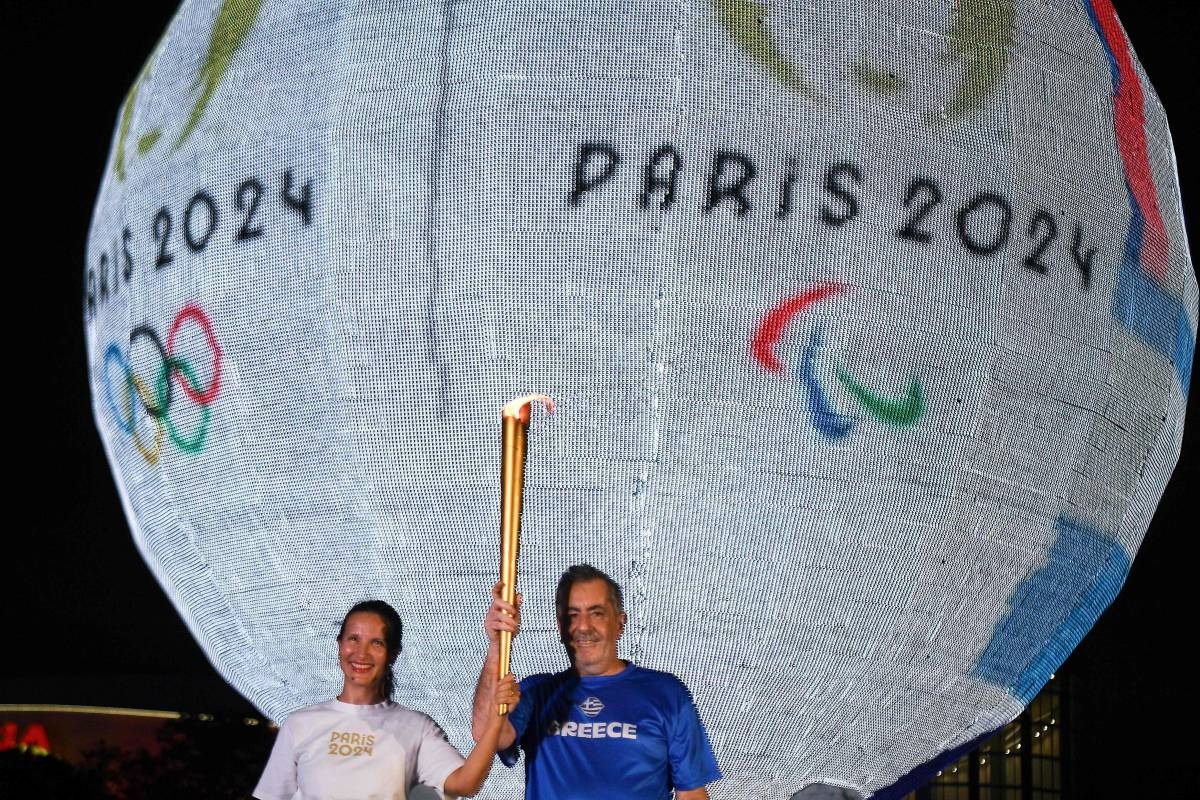 French Ambassador to the Philippines Marie Fontanel (left) and Greek Ambassador to the Phillippines Ioannis Pediotis hold a symbolic Olympic Flame during a symbolic relay event in front of the globe of the Mall of Asia in Manila on April 16, 2024, following the flame lighting ceremony for the Paris 2024 Olympics Games. AFP FILE PHOTO PHOTO