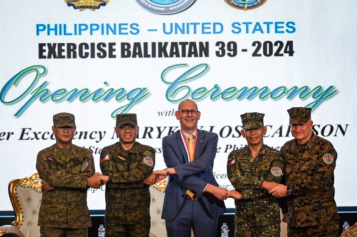 (From left) Philippines exercise director for Balikatan Major General Marvin Licudine, Armed Forces of the Philippines Chief of Staff General Romeo Brawner, US embassy in the Philippines Chargé d’Affaires Robert Ewing, Armed Forces of the Philippines deputy Chief of Staff for Education, Training and Doctrine Major General Noel Beleran and US exercise director for Balikatan Lieutenant General William Jurney link arms during the opening ceremony of the 'Balikatan' joint military exercise at Camp Aguinaldo in Quezon City, on April 22, 2024. PHOTO BY JAM STA ROSA / AFP