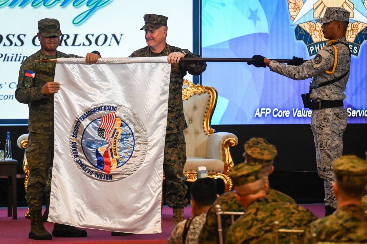 Philippines exercise director for Balikatan Major General Marvin Licudine (left) and US exercise director for Balikatan Lieutenant General William Jurney (R) unfurl the exercise flag during the opening ceremony of the 'Balikatan' joint military exercise at Camp Aguinaldo in Quezon City, on April 22, 2024. PHOTO BY JAM STA ROSA / AFP