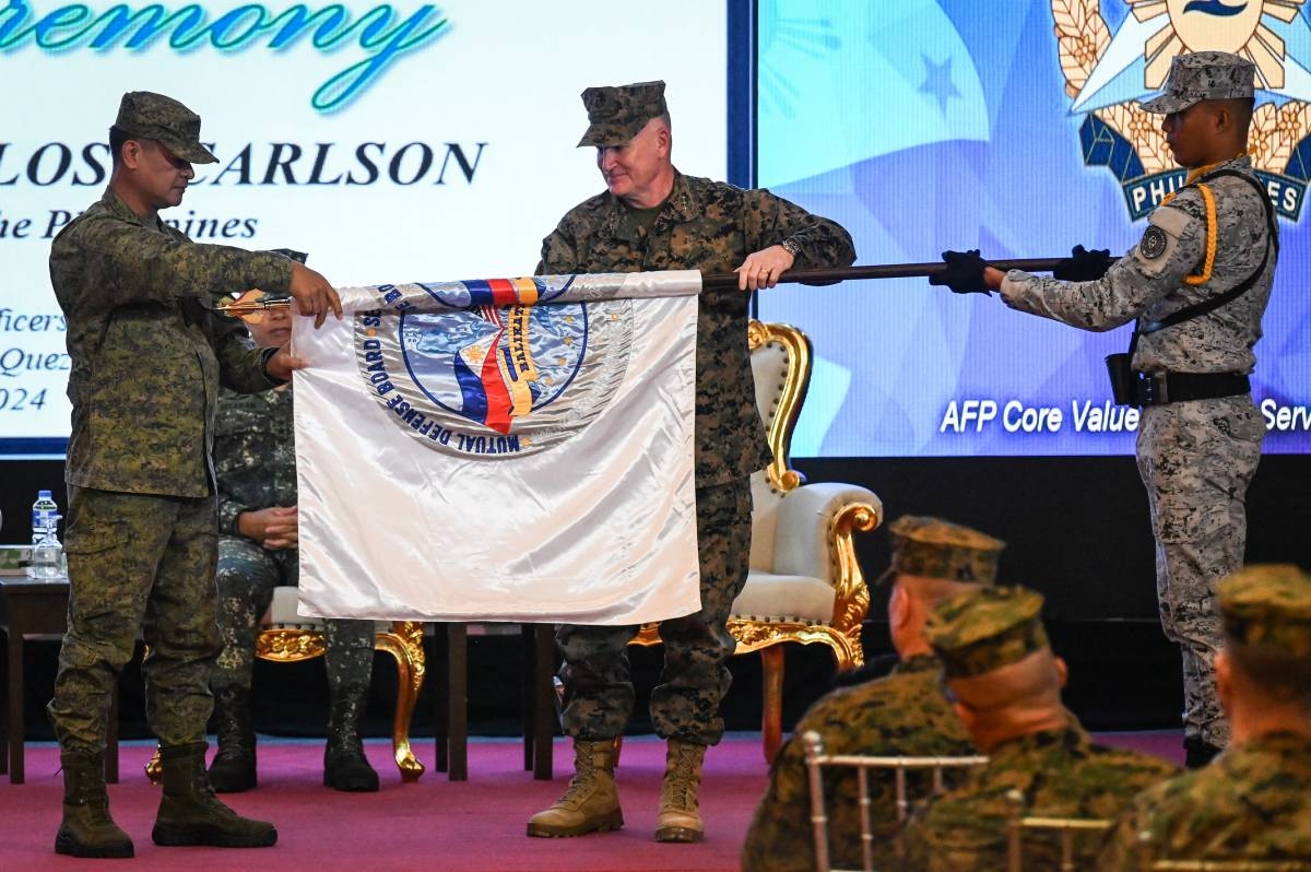 Philippines exercise director for Balikatan Major General Marvin Licudine (left) and US exercise director for Balikatan Lieutenant General William Jurney (right) unfurl the exercise flag during the opening ceremony of the 'Balikatan' joint military exercise at Camp Aguinaldo in Quezon City, on April 22, 2024. PHOTO BY JAM STA ROSA / AFP