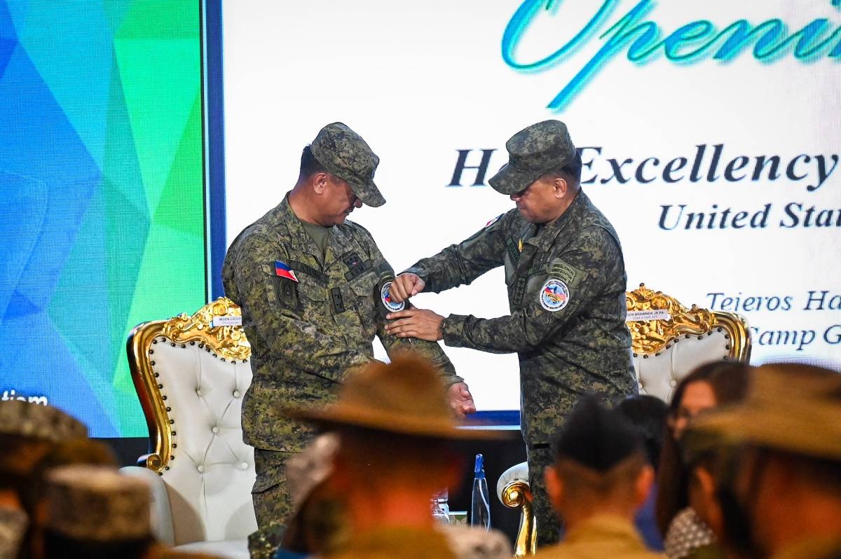 Armed Forces of the Philippines Chief of Staff General Romeo Brawner (right) puts a patch on Philippines exercise director for Balikatan Major General Marvin Licudine (left) during the opening ceremony of the 'Balikatan' joint military exercise at Camp Aguinaldo in Quezon City, on April 22, 2024. PHOTO BY JAM STA ROSA / AFP