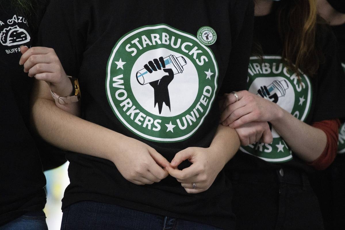 Starbucks employees and supporters link arms during a union election watch party Dec. 9, 2021, in Buffalo, New York. AP PHOTO