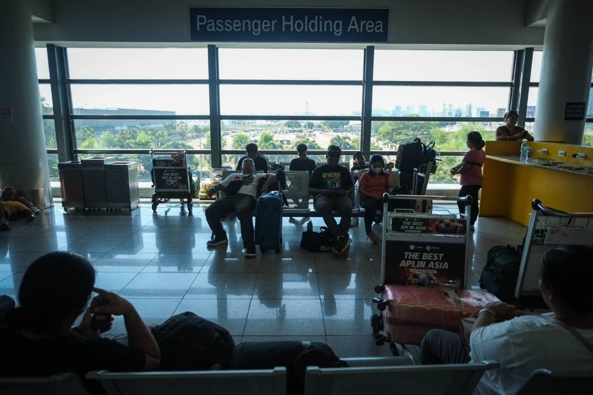 尼诺·阿基诺国际机场 (NAIA) 3 号航站楼内的乘客在两座冷却塔进行维护时承受着高温。 摄影：J. GERARD SEGUIA

