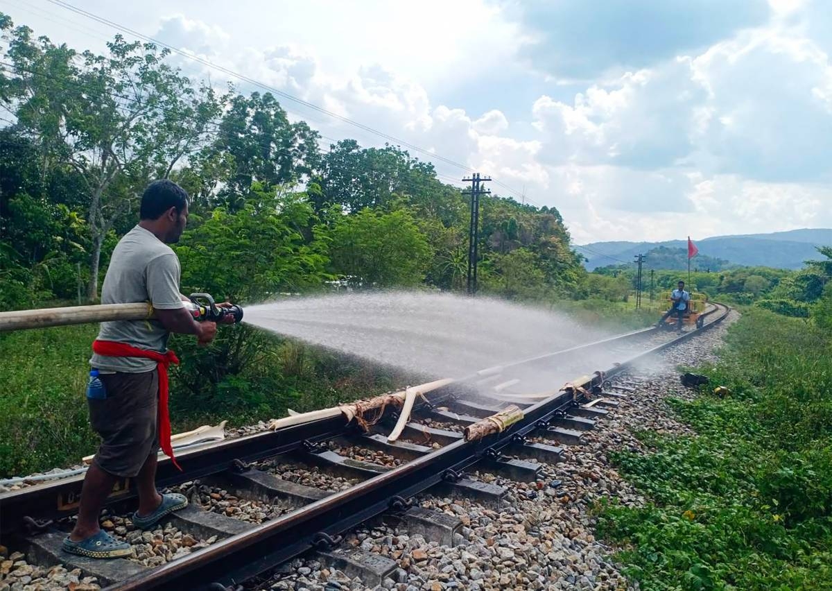 This handout photo taken on April 30, 2024 and released on May 2 by the State Railway of Thailand shows a worker spraying water on railway tracks warped by the heat between Ron Phibun district and Khao Chum in the southern Thai province of Nakhon Si Thammarat. Railway workers in southern Thailand's Nakhon Si Thammarat province doused buckled railway tracks with water to try to get them back into shape after the temperature hit 41 degrees Celsius (105 Fahrenheit), with the State Railway of Thailand saying the "extreme heat" was to blame for the tracks warping between Ron Phibun district and Khao Chum on April 30. Handout / State Railway of Thailand / AFP