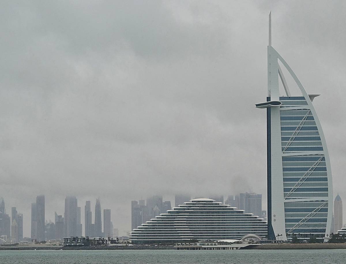 Thick clouds fill the sky above the Burj Al-Arab tower in Dubai on May 2, 2024, as heavy rains returned to the United Arab Emirates just two weeks after record downpours that experts linked to climate change. Photo by Giuseppe CACACE / AFP