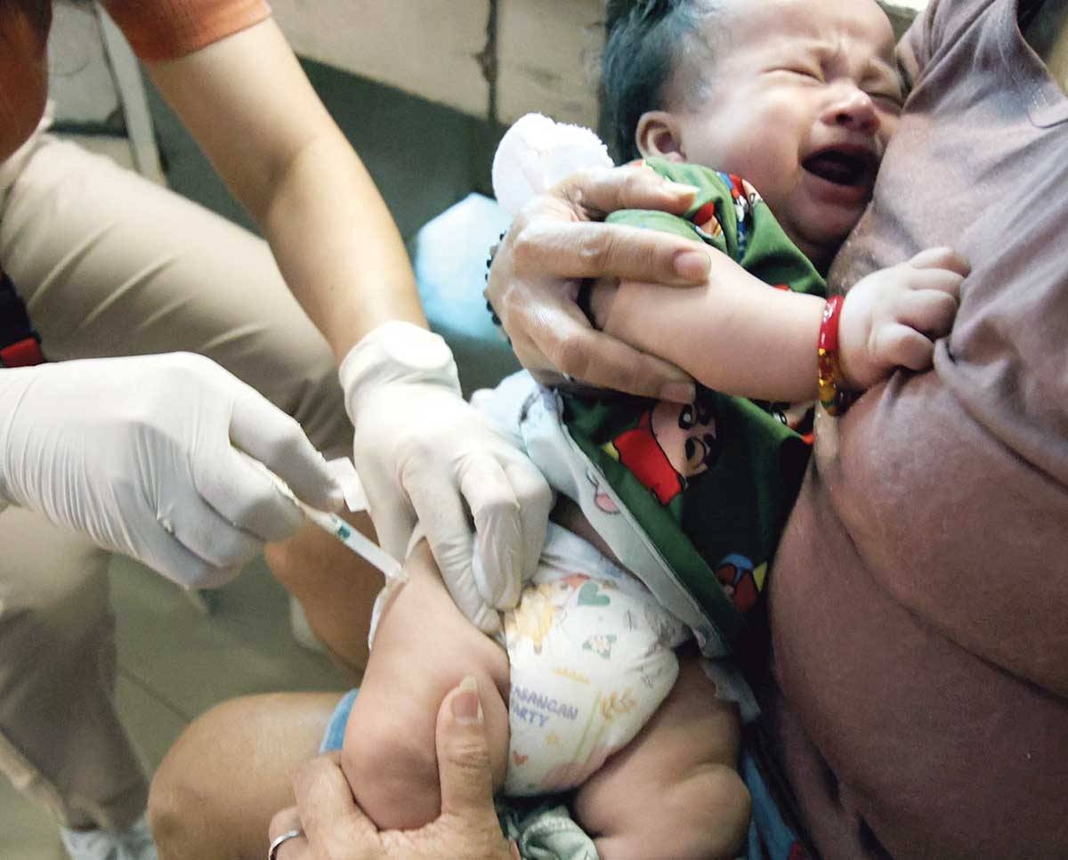 ‘THAT HURTS’ A health worker injects a pentavalent vaccine on an infant at a health center in Quezon City on Friday, March 22, 2024. The Quezon City government declared an outbreak of pertussis or whooping cough after logging 23 cases, including four deaths, mostly infants from 22 to 60 days old. PHOTO BY ISMAEL DE JUAN