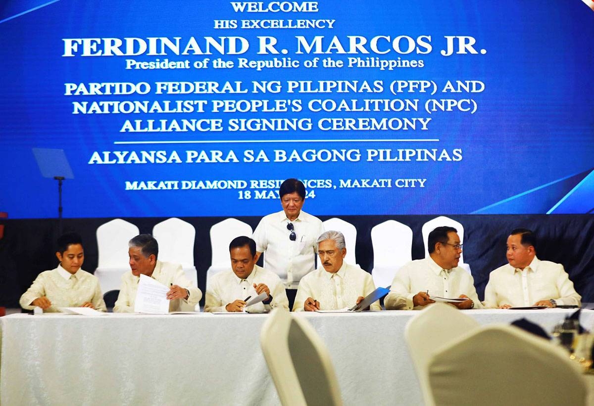 NEW ALLIANCE President Ferdinand Marcos Jr. (standing) witnesses the signing of an alliance between his Partido Federal ng Pilipinas and the Nationalist People’s Coalition, led by its chairman and former Senate president Vicente Sotto III in Makati on May 18, 2024. South Cotabato Gov. Reynaldo Tamayo Jr. represented PFP as its president. Seated (from left) are llocos Norte 1st District Rep. Ferdinand Alexander Marcos, Special Assistant to the President Antonio Lagdameo Jr., Tamayo, Sotto, Rizal 1st District Rep. Michael John Duavit, and Secretary Mark Llandro Mendoza, presidential adviser on legislative affairs and head of the presidential legislative liaison office. PHOTO BY MIKE ALQUINTO