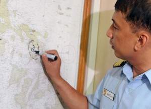 Philippine Coast Guard (PCG) spokesperson Commander Arman Balilo points to a Philippine map where the ferry MV Lady of Mount Carmel capsized about two kilometres (1.2 miles) from Burias island, at the PCG headquarters.