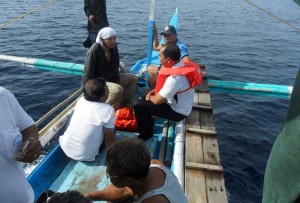 A handout photo taken on June 14, 2013 and released by the National Disaster Risk Reduction and Management Council (NDRRMC) shows survivors, of the sunken Our Lady of Mount Carmel ferry, being taken aboard a boat by their rescuers Off Burias Island.  AFP PHOTO / HO / NDRRMC