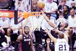  LeBron James (left) of the Miami Heat watches as teammate Dwayne Wade (right) scores under pressure from Tim Duncan (center) of the San Antonio Spurs during Game 4 of the NBA finals.  AFP PHOTO 